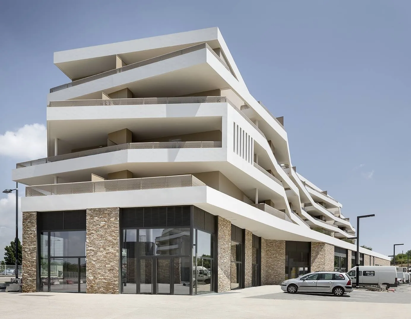Programme de logements contemporain, façades blanches, balcons et volumes architecturaux